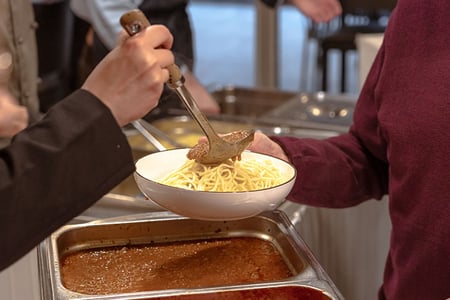 Spagetti in einer Schüssel auf die Sosse getan wird Spagetti in einer Schüssel auf die Sosse getan wird
