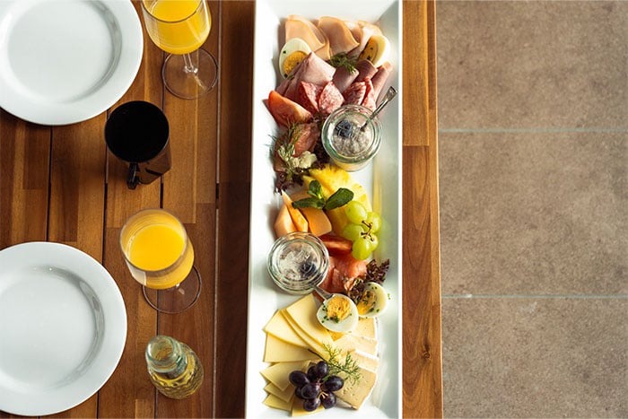Zwei Teller, zwei Gläser Orangensaft und eine Brunchplatte auf einem Tisch Zwei Teller, zwei Gläser Orangensaft und eine Brunchplatte auf einem Tisch
